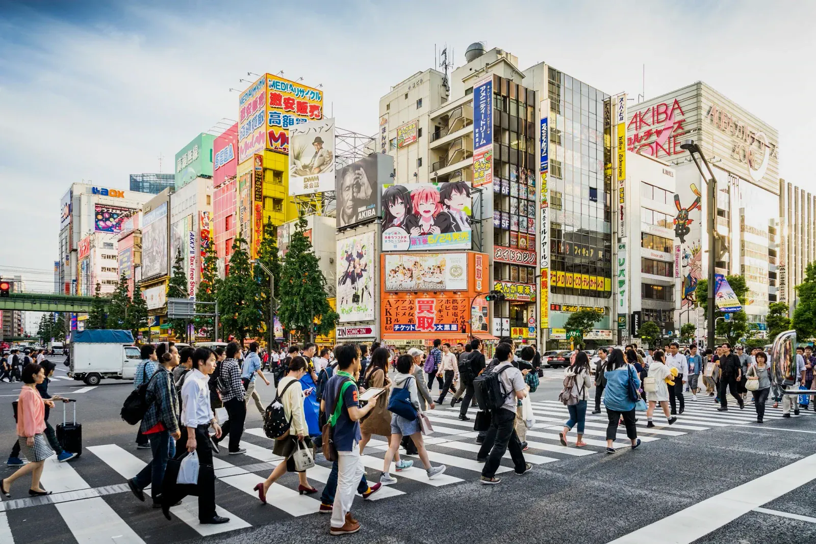 Akihabara crossing with pedestrians and colourful anime-covered buildings