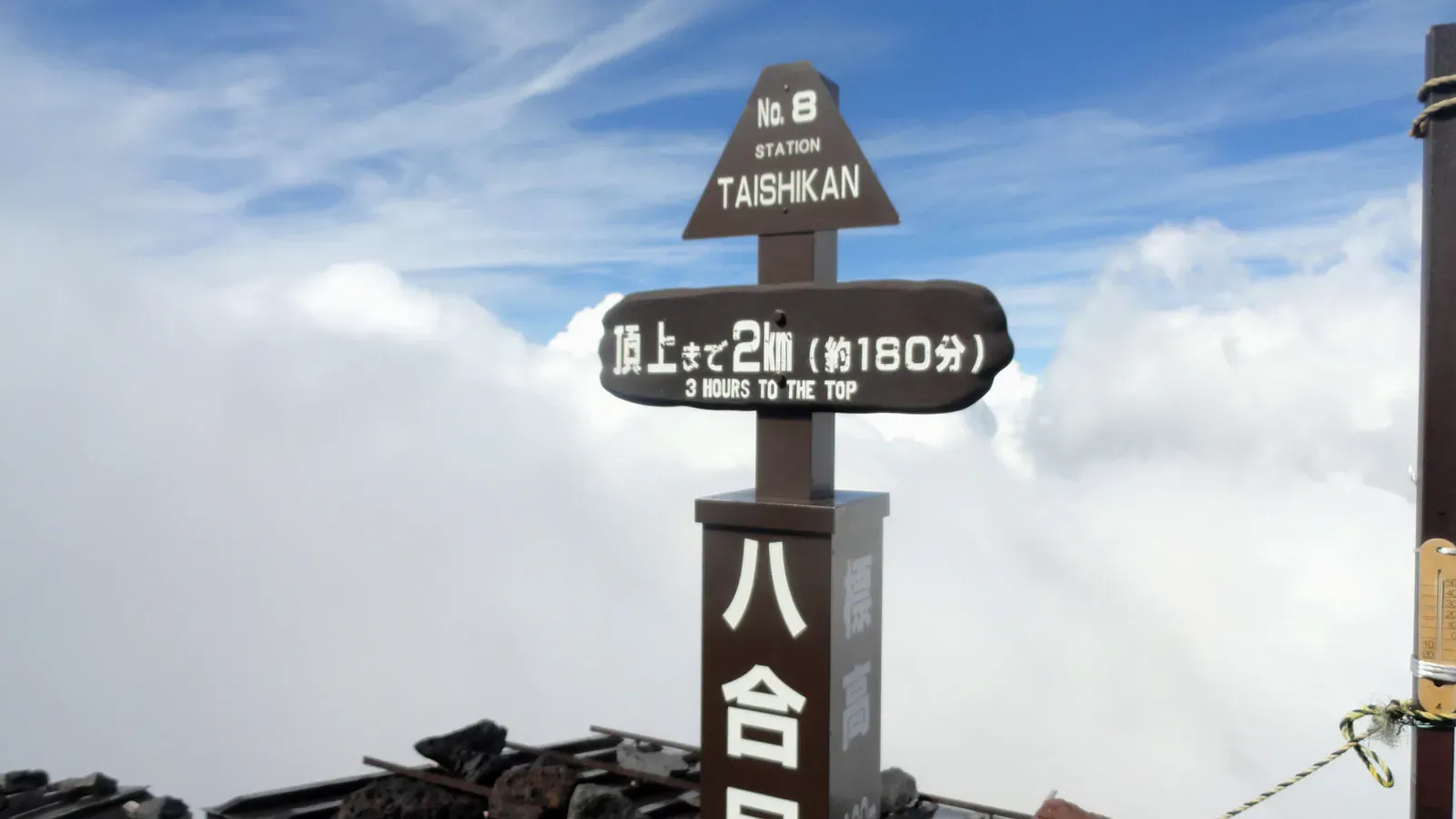Eighth-station Taishikan hut sign above the clouds on Mount Fuji