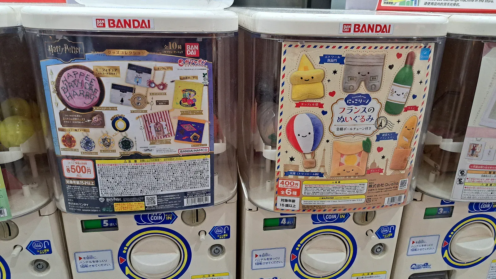 Rows of Bandai capsule toy machines with product cards