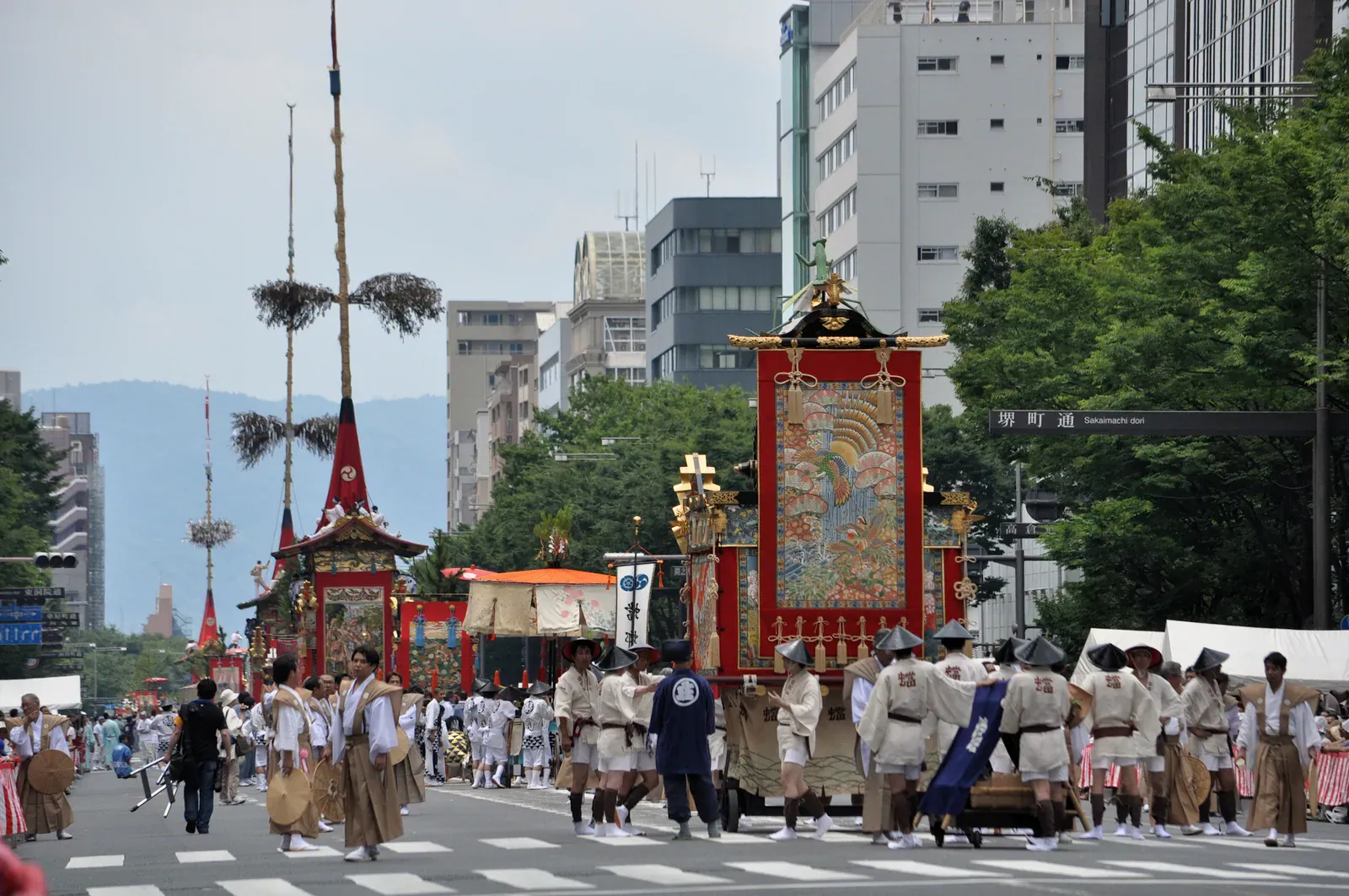 Gion Matsuri float with red tapestries pulled down a Kyoto street
