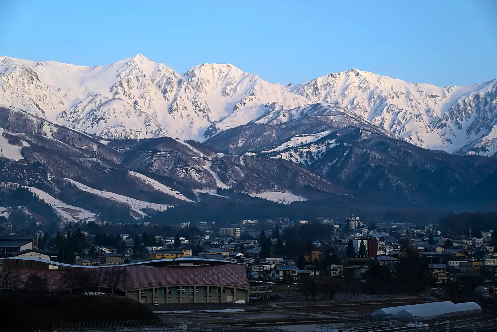 Hakuba valley town below snow-covered Japan Alps in clear winter light
