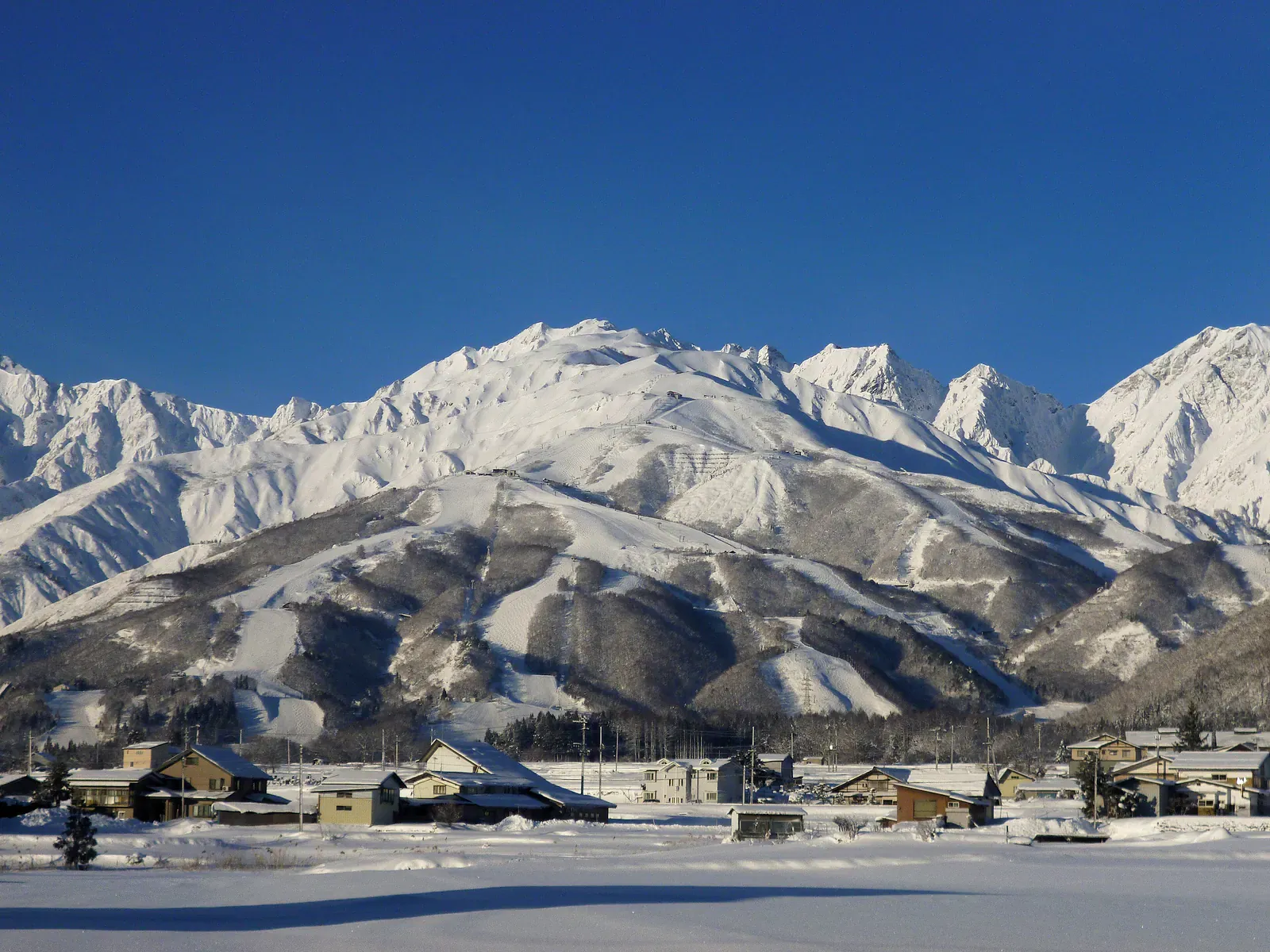 Snow-covered mountain ridge above a valley village in winter