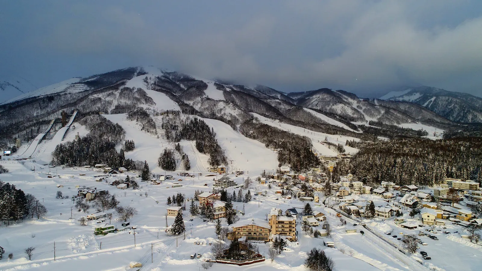 Ski resort buildings below snowy slopes