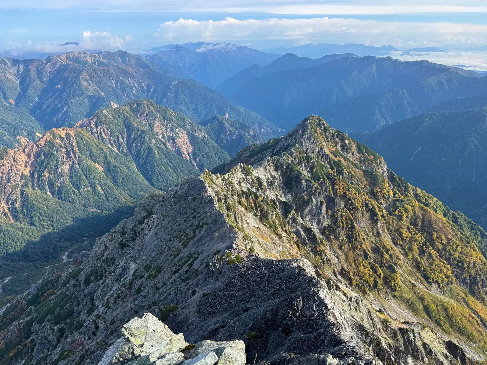 Jagged sunlit Japan Alps ridge with layered peaks beyond