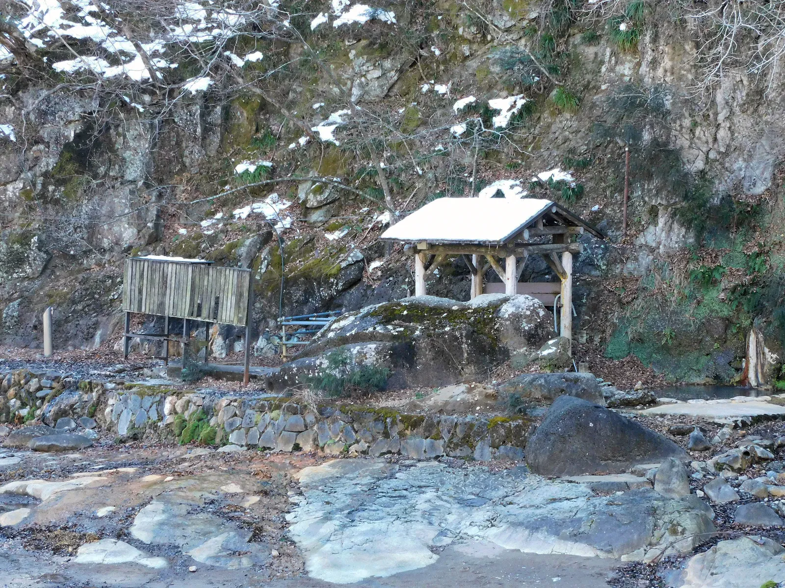 Rock hot spring with a small hut in the snow in Japan