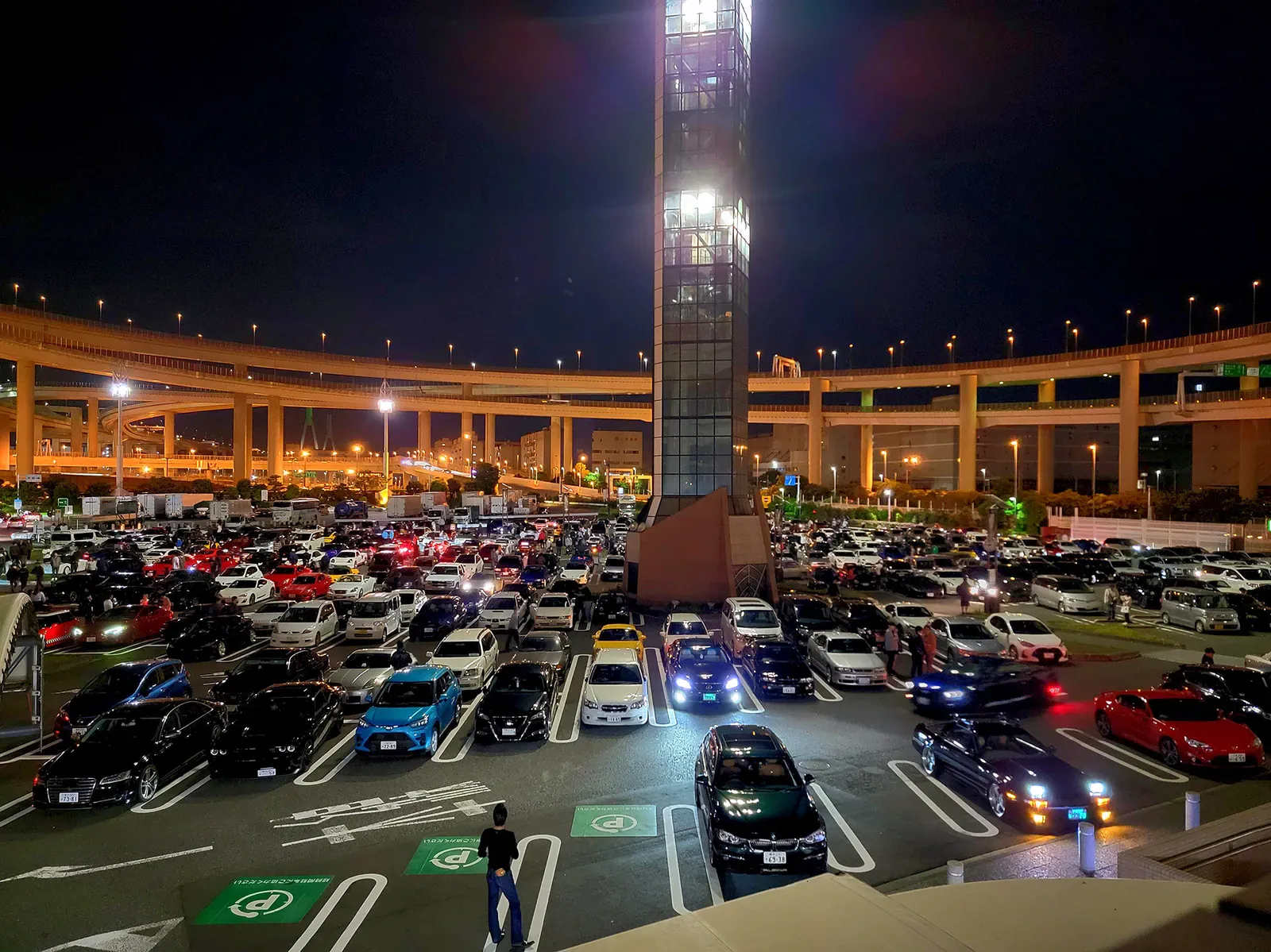Overhead view of a packed night car park with rows of tuned cars