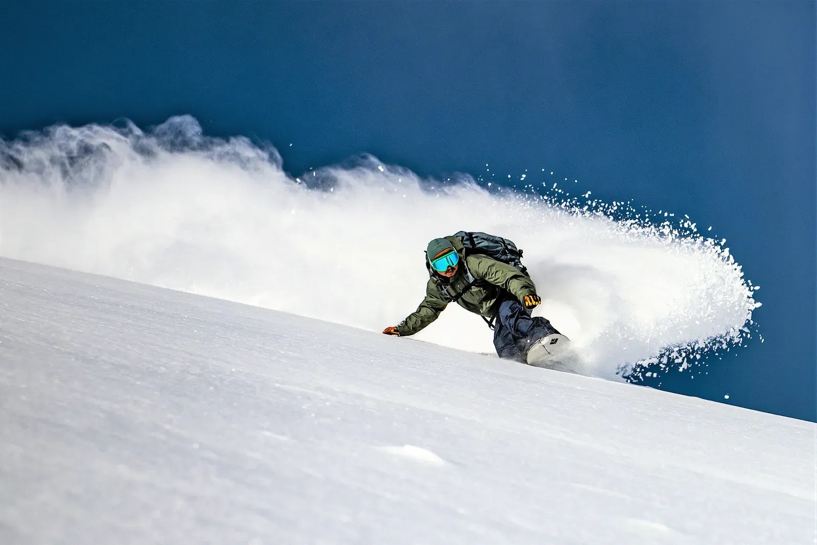 Snowboarder carving through powder