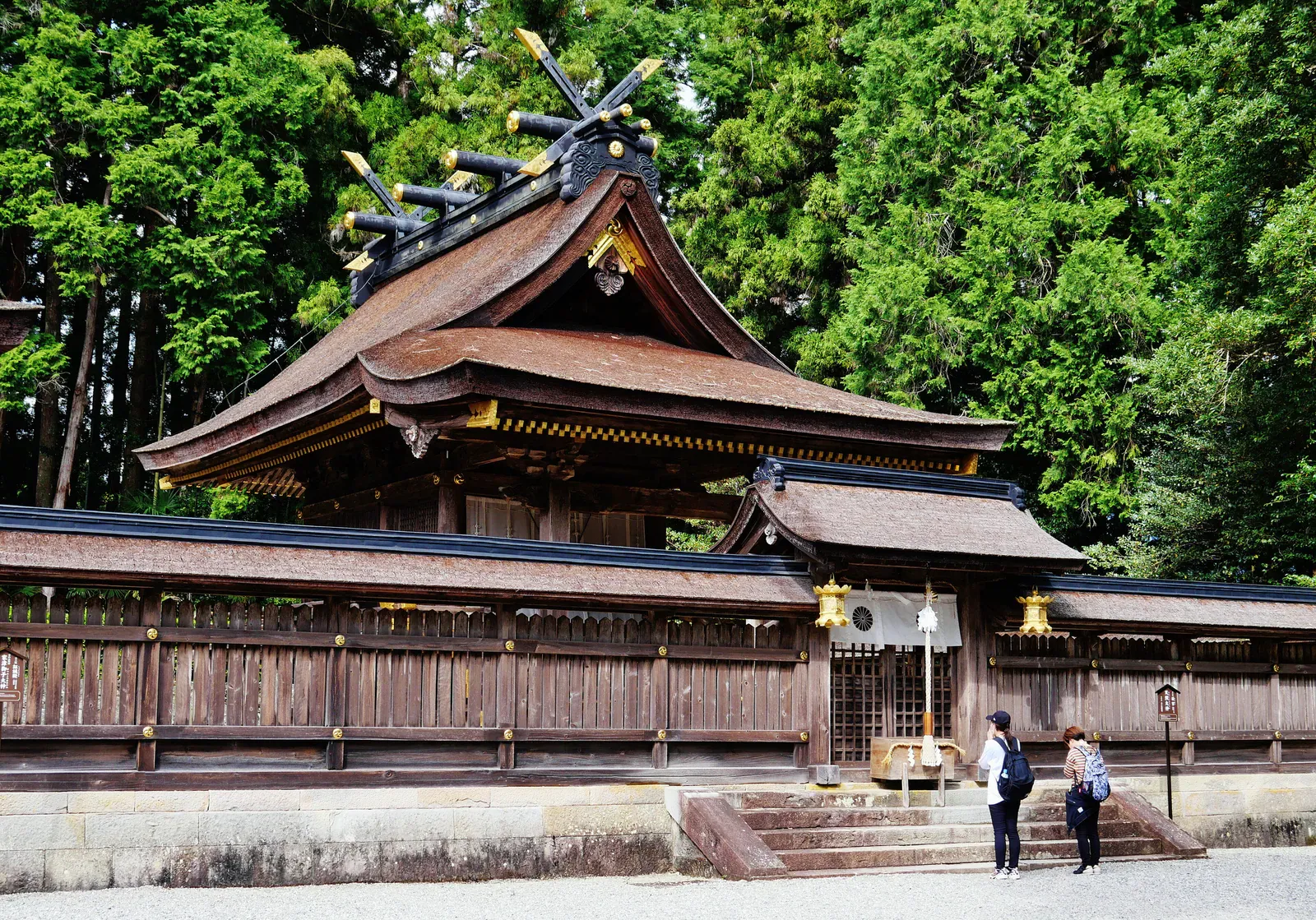 Cypress-bark roofed shrine hall at Kumano Hongu Taisha with two visitors