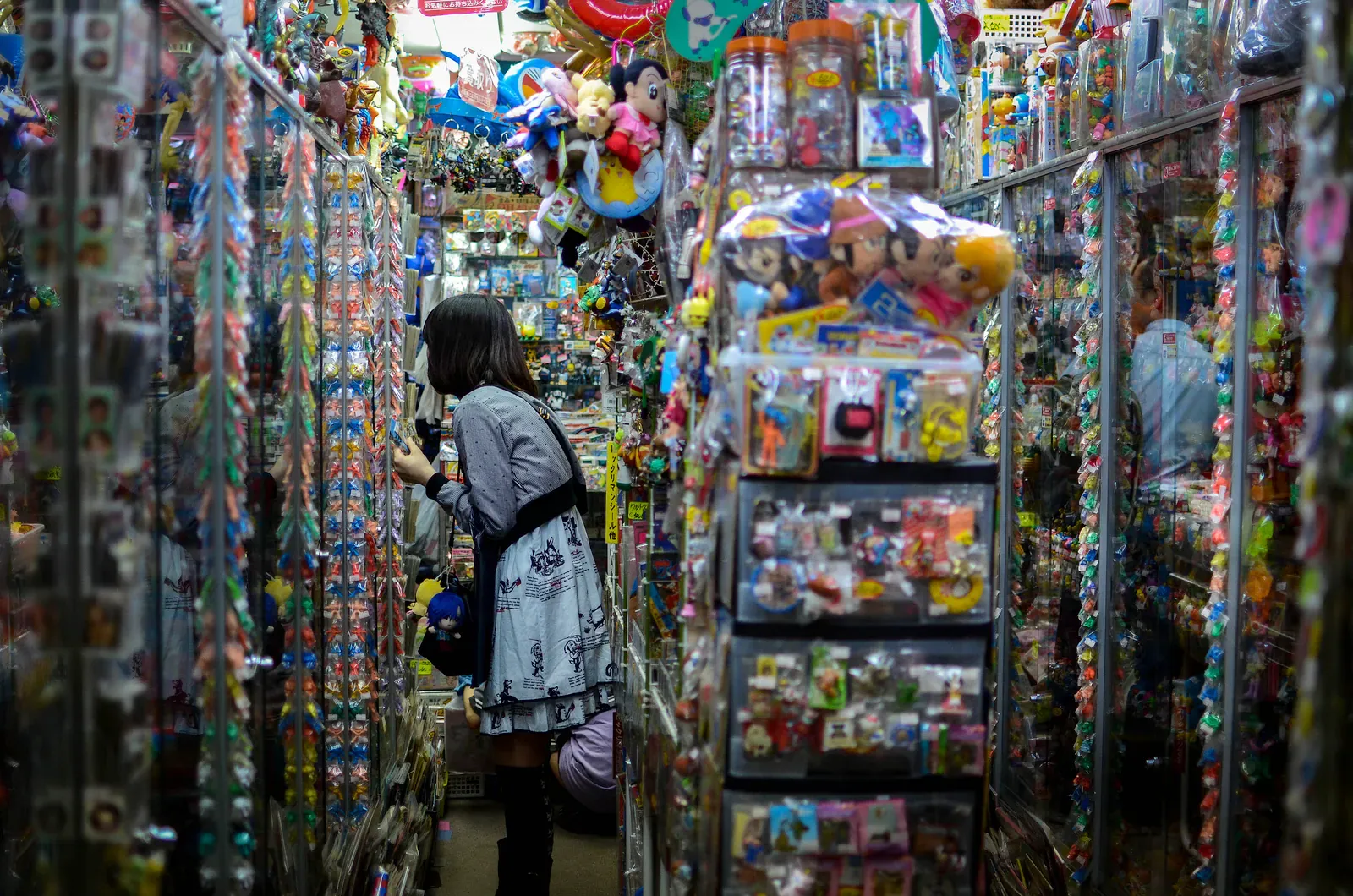 Narrow collectibles aisle packed floor to ceiling with toys and capsules