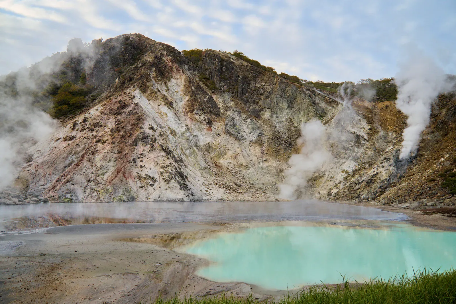 Turquoise hot spring pool in a volcanic crater at Noboribetsu