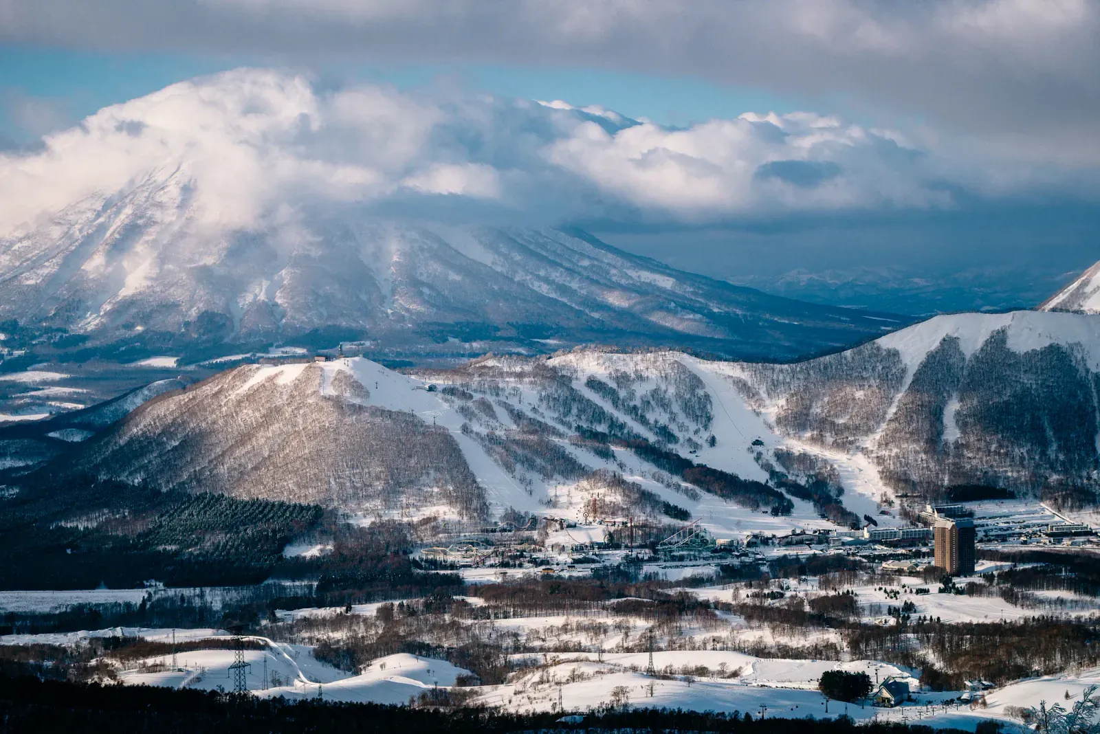 Rusutsu slopes and snowy volcanic peaks seen from above on a clear winter day