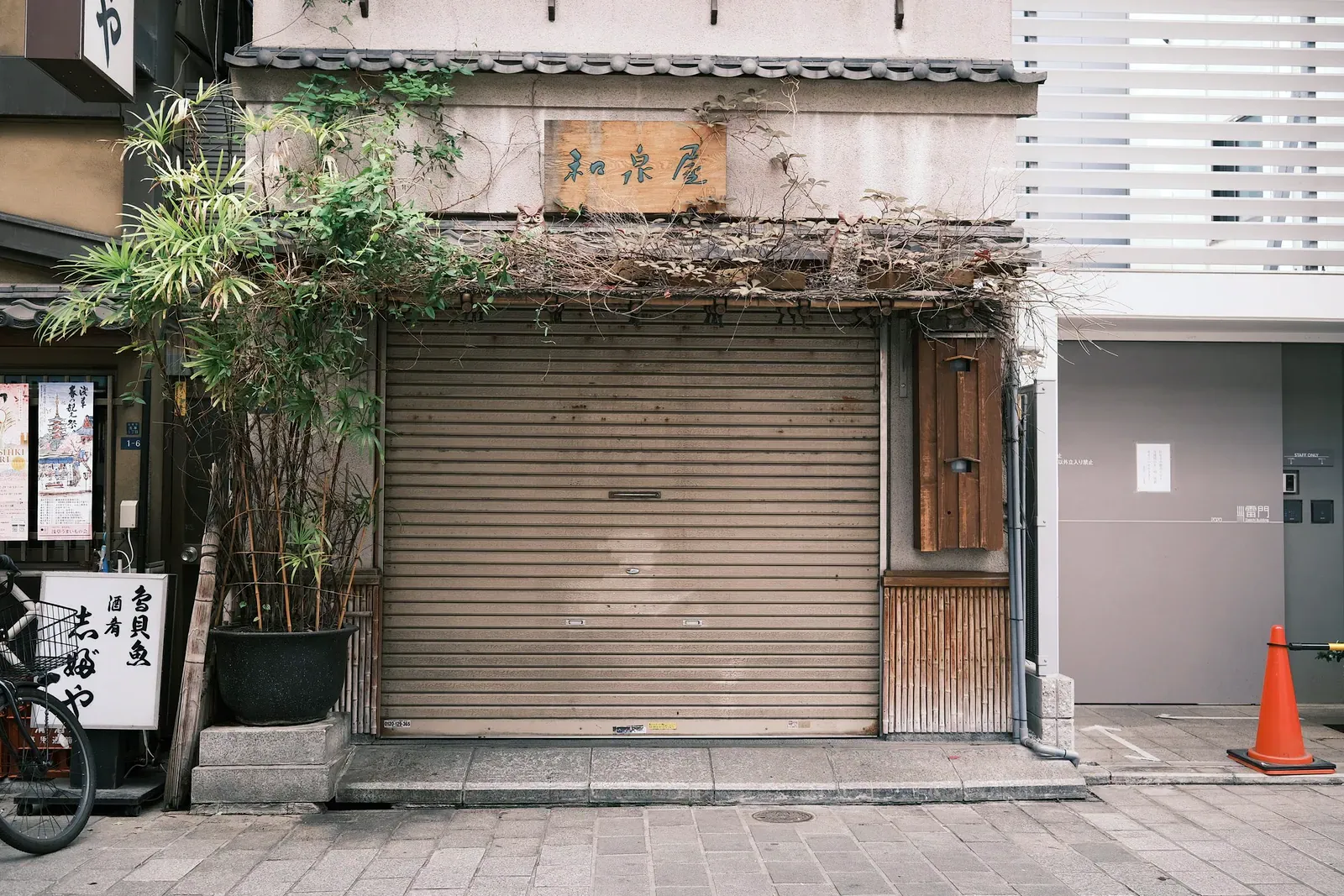 Shuttered wooden shopfront with its roller shutter closed on a Japanese street